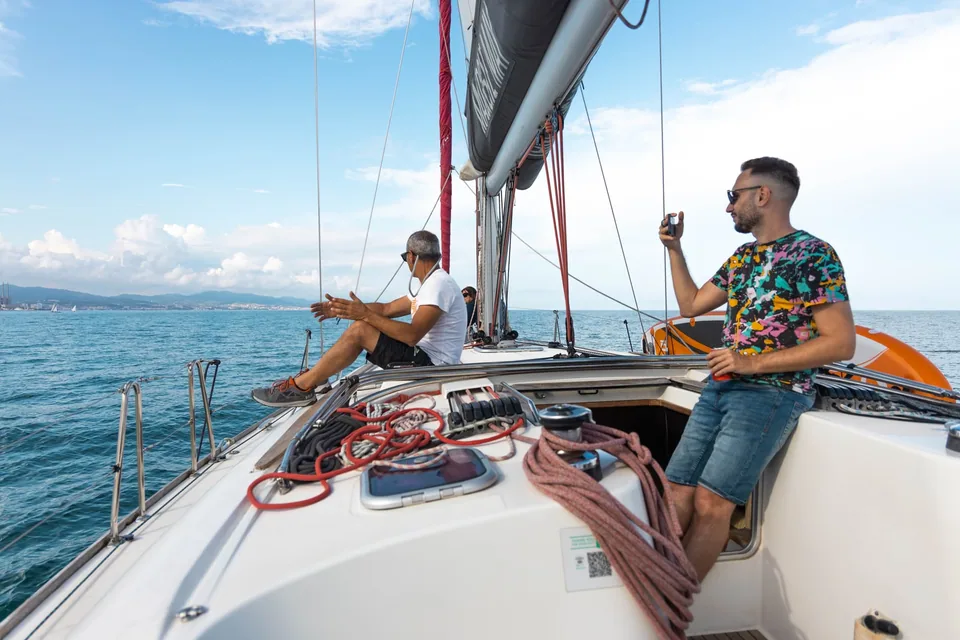 Two people relaxing comfortably aboard a sailboat on the Barcelona coast